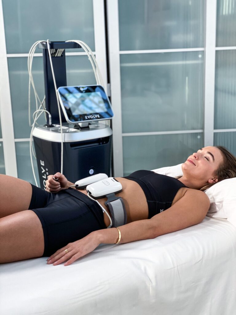 Young adult female receiving Evolve Body Sculpting Treatment on abs