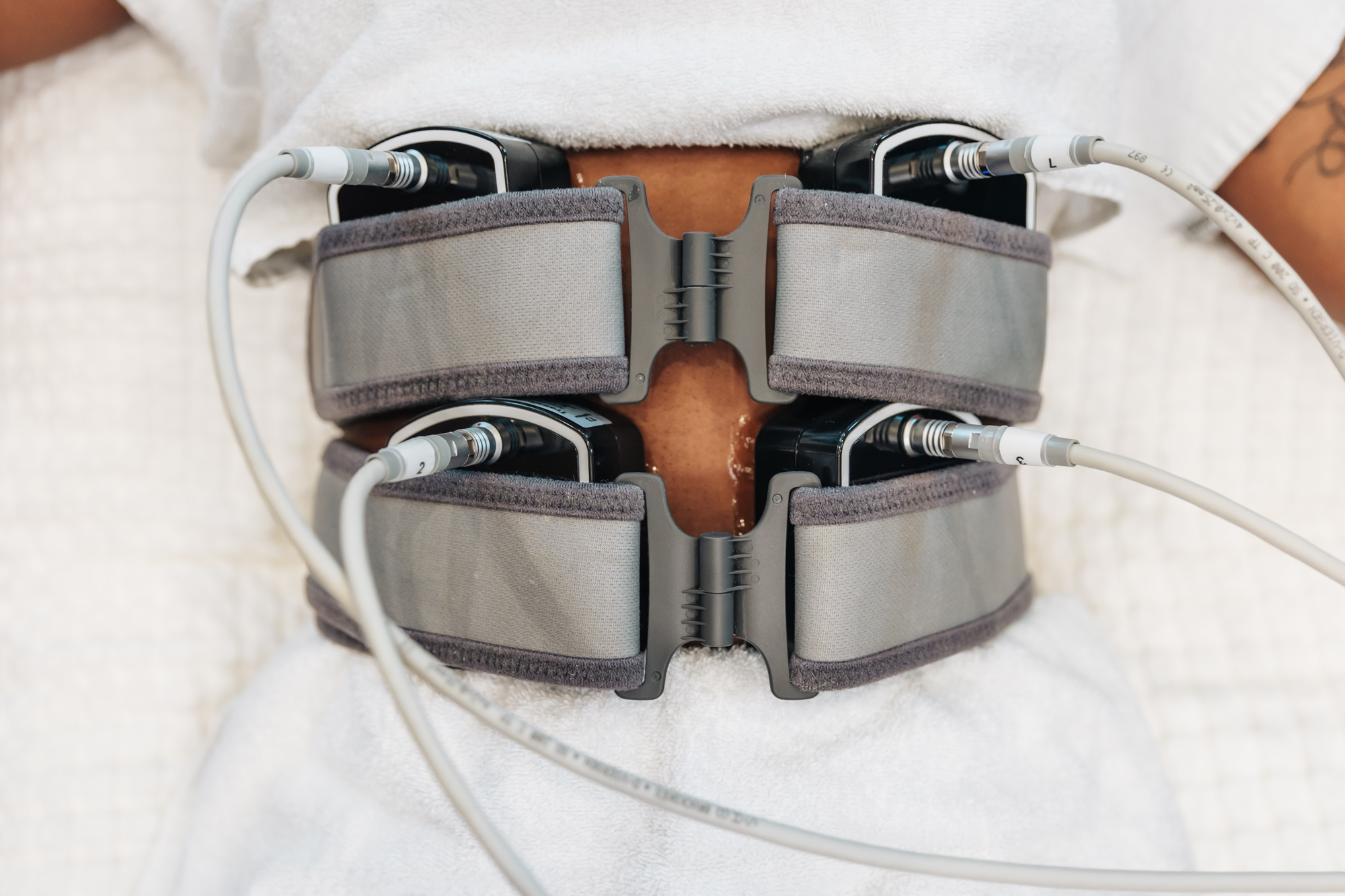 The EvolveX applicator stimulates muscle contraction in the patient's abdomen, but with smaller applicators than Emsculpt NEO near Knoxville.